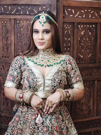 The full look featuring the green beaded Kundan choker and matha patti, paired with a multi-coloured printed lehenga.
