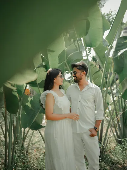 An intimate moment with foreheads touching, framed by the vibrant green leaves of a Pune garden. This shot feels private and serene, perfectly capturing the couple's deep connection.