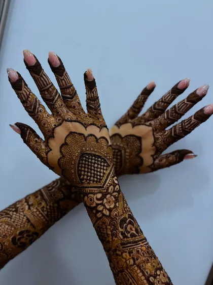 A beautiful bridal henna design with a scalloped border, creating an elegant and unique look.