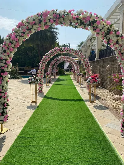 We believe in fairytale entrances. This series of lush floral arches in pink and white created a dreamy pathway for the bride and groom during their daytime wedding ceremony at Raheja Exotica.