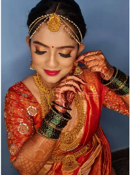 Getting the lovely Geetha ready for her big day. This candid shot captures the final moments of her bridal transformation.