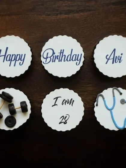 A top-down view of the custom cupcake toppers for a doctor and gym junkie. You can see the detail in the fondant stethoscope and the miniature weights, making it a truly personalized birthday gift.