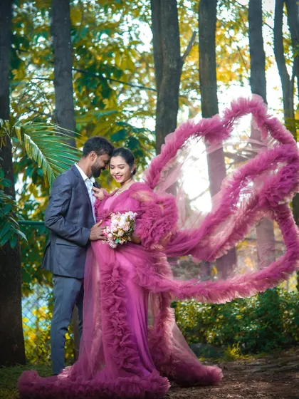 This dramatic pink gown features a long, ruffled train that can be shaped into stunning designs, like this heart. It's an artistic choice for a truly unique maternity photo.