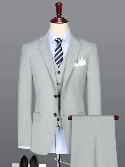 A light grey three-piece suit, a perfect choice for summer formal wear. The fit is modern and the color is sophisticated.