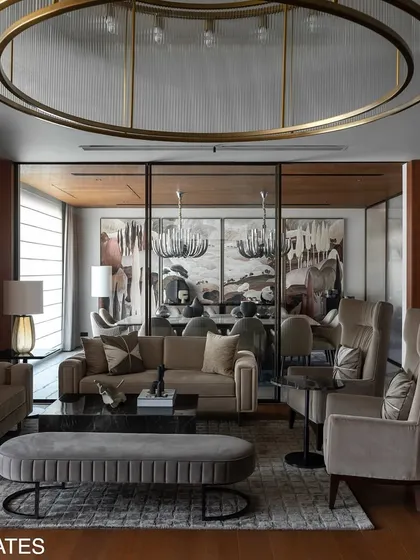 The formal living room in Residence 338 uses a monochrome palette of stone, veneer, and gray tones, punctuated by curated artwork to create a unified and tranquil atmosphere.