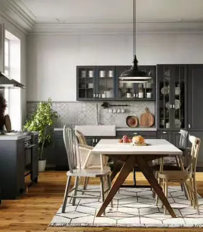 A farmhouse-style kitchen and dining area with dark cabinets, a classic apron sink, and natural wood floors.
