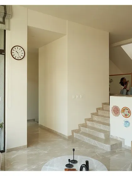 This view shows the multiple levels and connections within the home, from the living area to the stairs and the small balcony. The design encourages movement and interaction.