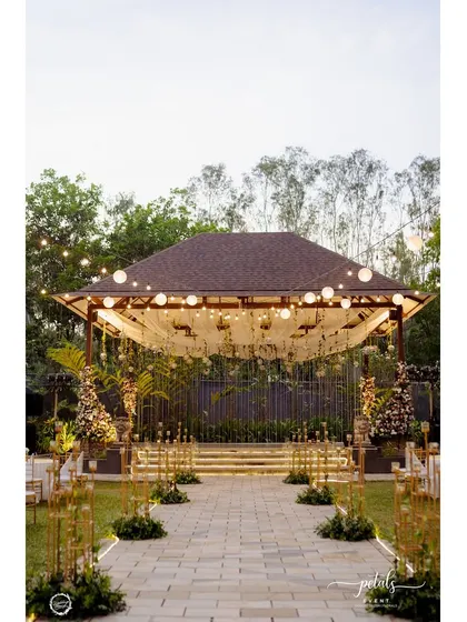 The entrance to the Sangeet is a broken arch of metal frames and florals, creating a modern and dreamlike welcome for guests.