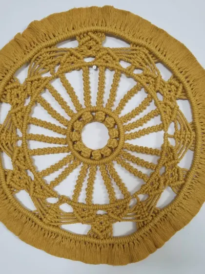 This large, mustard-yellow macrame mandala is a true statement piece. The circular design, full of intricate knots and patterns, brings a sense of harmony and focus to any wall.