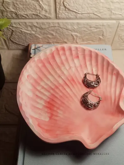 A peachy-white marble clam shell dish, perfect for holding a few favorite earrings.