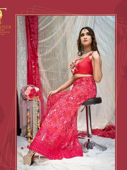 A professional shot of our red sharara set, featuring a one-shoulder embroidered top and printed flared pants. Perfect for a festive party.