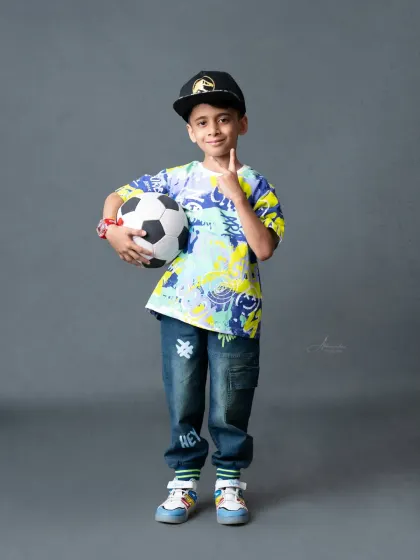 Ready to play! This young boy's energetic personality shines through in this fun, sporty portrait.