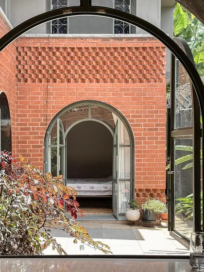 A detailed view through the kitchen window, showing the intricate brickwork and arched opening of the opposite building. This layering of views adds depth and character to the home.