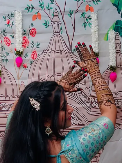 A bride posing with her intricate mehendi, showing how the design becomes a beautiful accessory to her overall look.