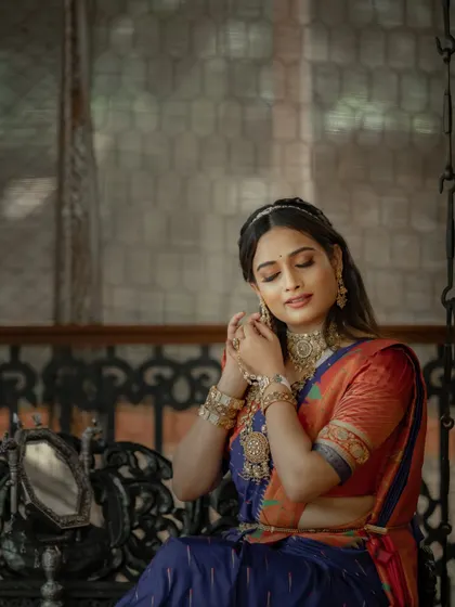 A moment of quiet reflection on the swing, the intricate details of the Paithani saree visible in the soft light.