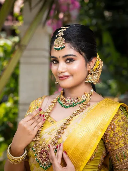 A close-up of the model, showcasing the beautiful matha patti, choker, and haram with matching ear chains.
