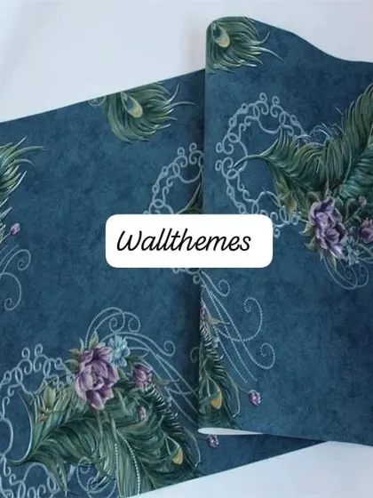 A close-up of a deep blue wallpaper with a subtle pattern of peacock feathers and silver swirls.