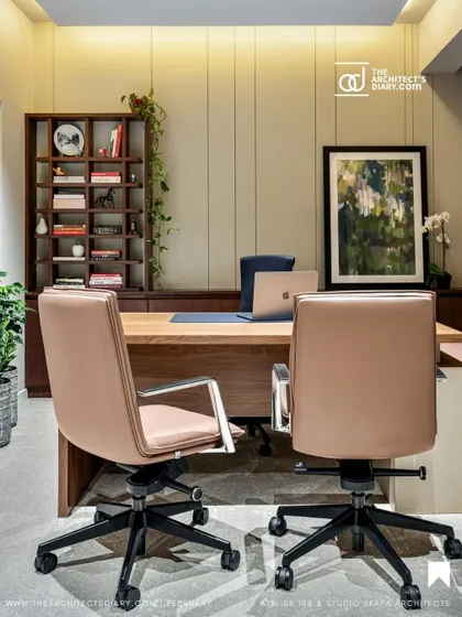This cabin combines warm wood shelving and paneling with sleek, modern furniture. The design provides a functional workspace that feels personal and sophisticated, complete with curated art and greenery.
