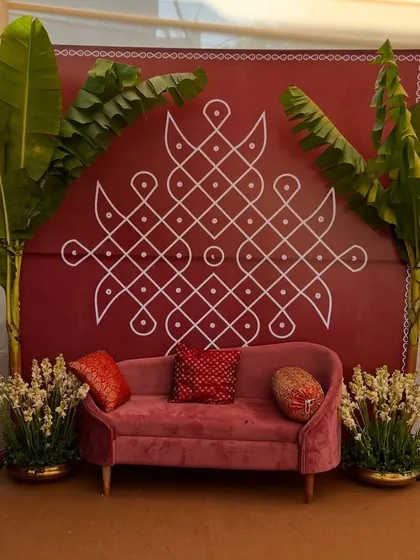 This decor brings back so much nostalgia. A simple red backdrop with a large Kolam design, flanked by banana trees, creates a warm and welcoming photo corner.