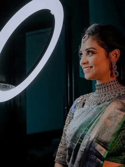 A striking pose with a ring light, showing off this beautiful reception look. The diamond choker and intricate blouse details are complemented by a sophisticated makeup style.
