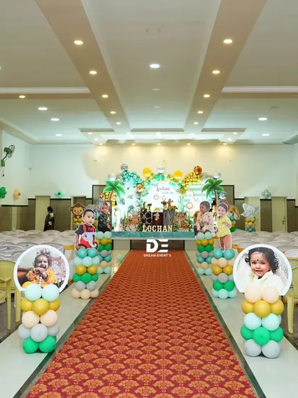 The entrance to Lochan's jungle party, with a red carpet aisle lined with balloon columns and personalized photo displays of the birthday boy.