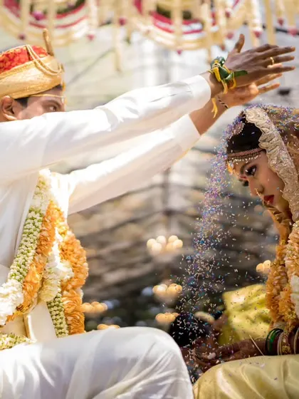 The Akshata ritual, where the couple showers each other with sacred rice. This shot captures the motion and the tradition in a bright, joyous frame.