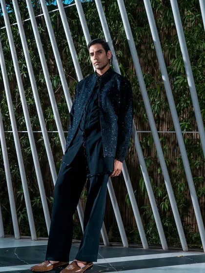 A full-length view of a black, subtly embellished Indo-Western outfit. The relaxed yet structured silhouette offers a sophisticated and comfortable option for evening festivities.
