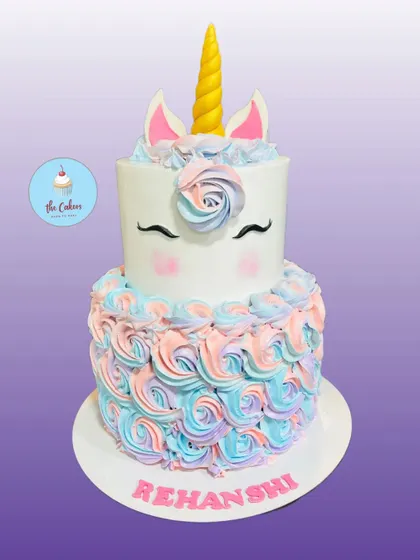 A classic two-tier unicorn cake with a buttercream mane of pastel swirls. This design features the iconic golden horn and sleepy eyes for a truly magical look.