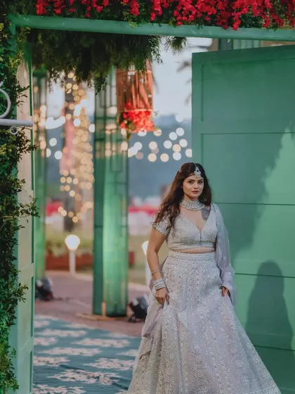 The bride makes her entrance through a beautiful green doorway adorned with flowers. This setup created a stunning frame for her arrival at the Roce ceremony.