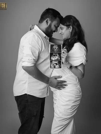 Sharing the first glimpse of their baby. The couple holds up their ultrasound pictures in this touching black and white studio photo.