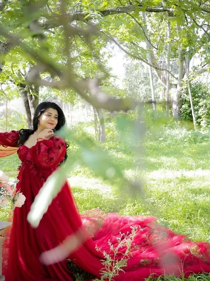 A duplicate of image 33, this beautiful outdoor portrait in a lush green park shows off a stunning red gown against nature's backdrop.