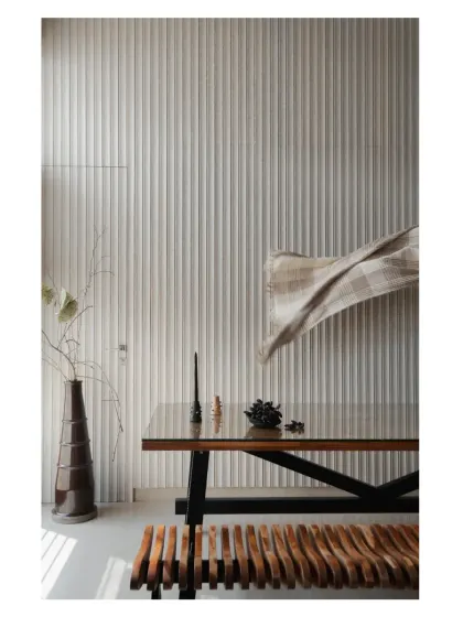 A sunny spot in the dining area, where different shades of wood and a textured fluted wall create a warm and inviting composition.