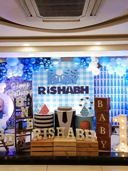 A classic Boss Baby theme for Rishabh's first birthday. This setup includes a blue and white color scheme, character cutouts, and a personalized milestone board.