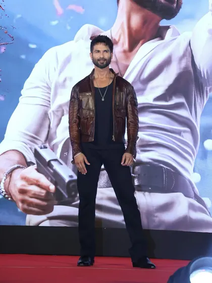The full look on stage. The slim-fit black pants and rugged leather jacket create a sharp and powerful silhouette.
