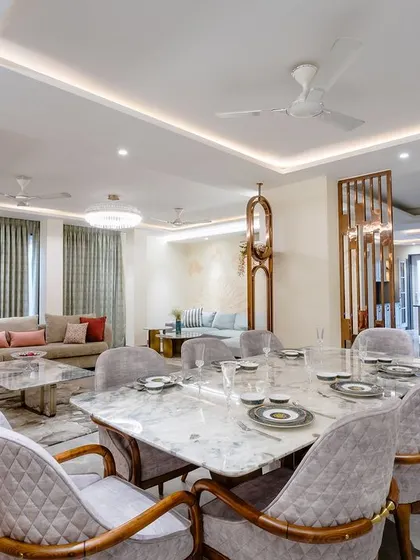 This angle shows the dining area as part of a larger open-plan space, with decorative metal partitions subtly dividing the zones.