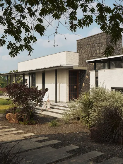 A duplicate of image 21, showing the entrance of Pavilion House with its mix of stone, brick, and lush landscaping.