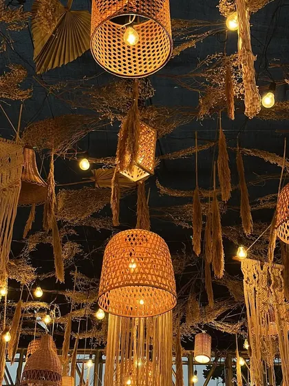 Another angle of the stunning ceiling treatment for the boho reception. The mix of textures, from woven lanterns to macrame and dried grasses, is key to achieving an authentic bohemian look.