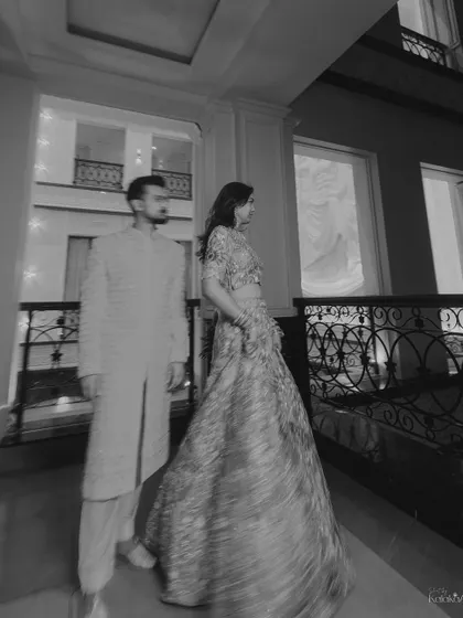 An artistic black and white photo with motion blur, creating a dynamic and timeless portrait of the couple in a grand hallway.