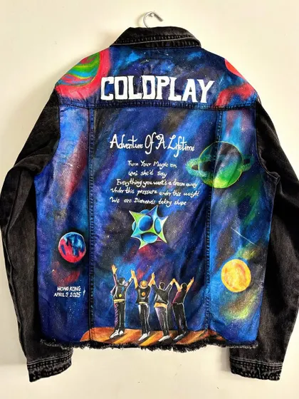 Another take on a Coldplay-themed jacket, this time on black denim. This piece features a different cosmic design inspired by their "Adventure of a Lifetime" theme, complete with planets, stars, and hand-lettered lyrics, created for a fan's concert experience in Hong Kong.