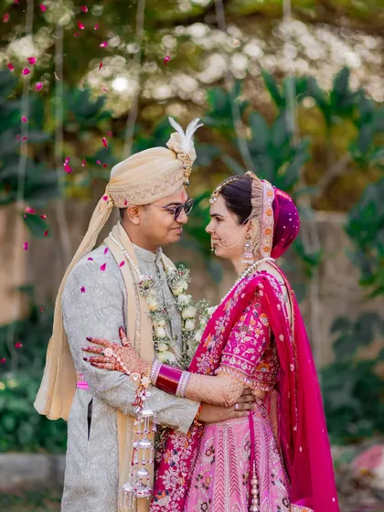 A romantic portrait of the couple in a garden, sharing a loving gaze under a gentle shower of petals.