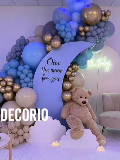 I love mixing themes to create something unique, like this "Over the moon for you" baby shower decor. It combines the dreamy moon element with a cuddly teddy bear and a sophisticated blue, grey, and gold balloon arrangement.
