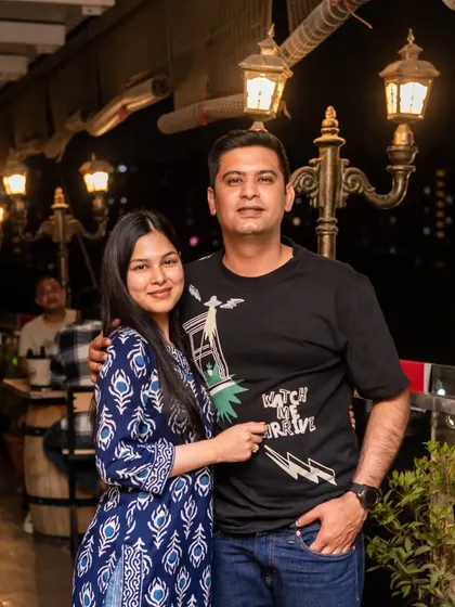 A couple posing on the rooftop, with the vintage lampposts and night sky creating a beautiful backdrop.