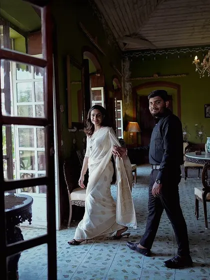 A candid moment of the couple walking through a heritage property, framed by a doorway. This shot feels like a glimpse into a private, happy moment.