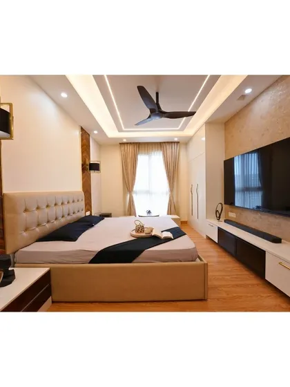A still from our latest project at Assetz Marq Whitefield, this master bedroom showcases a tufted headboard, elegant ceiling design, and a full-wall entertainment unit.