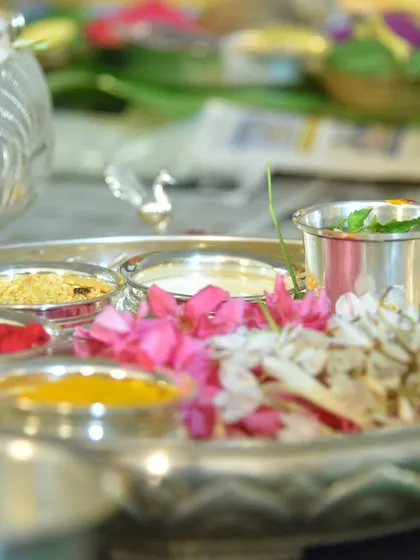 A close-up of the pooja thali, filled with flowers, kumkuma, and other offerings. These shots highlight the beauty and preparation that go into a traditional ceremony.