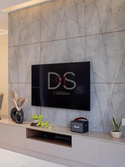 A custom TV unit with a grey marble-finish panel, providing a sleek and modern focal point for the living room.
