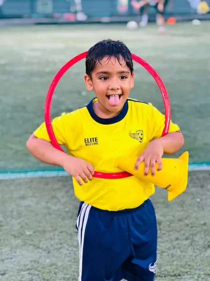 A player makes a funny face while holding a hoop. It's all about having a good time while learning.