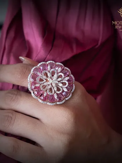 A floral cocktail ring crafted with vibrant pink tourmalines and diamonds. The intricate design and beautiful color make this a standout piece for any occasion.