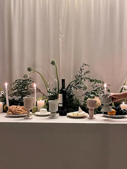 A wide shot of the beautifully styled tablescape, featuring our full collection of collaborative goblets. It's a story of passion and creativity, from an idea to the dinner table.