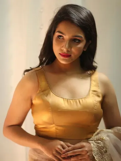 A simple and elegant sleeveless gold blouse with a scoop neckline. This is a timeless piece that you'll wear for years to come.